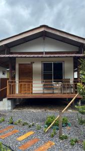 une petite maison avec un grand porche dans l'établissement Cha homestay, à Phanom 11 autres photos