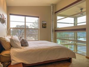 ein Schlafzimmer mit einem Bett und zwei großen Fenstern in der Unterkunft Urban Loft 30 day minimum in Hood River