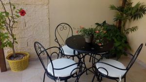 una mesa negra y sillas con plantas y flores en Affittacamere Carpe Diem, en Gonnosfanàdiga