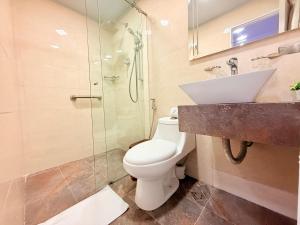 a bathroom with a toilet and a shower and a sink at Hotel Veler in Medellín