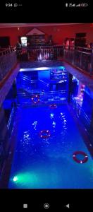 una piscina de agua azul en un bar en Uptown Life Hotel and Suites, en Warri