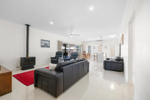 a living room with two leather couches and a television at Sea La Vie in Arakoon