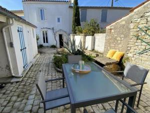 une table et des chaises bleues sur un patio en briques dans l'établissement Maison de charme 4 pièces à Saint-Denis d'Oléron, 6 couchages - FR-1-246A-164, à Saint-Denis-dʼOléron