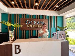 a woman standing behind a counter in an ocean garden lobby at Ocean Verde Suite Boracay in Boracay +25 photos