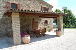 a stone house with a patio with a table and chairs at Solaria Orvieto in Orvieto