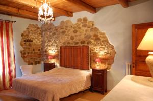 ein Schlafzimmer mit einem Bett mit einer Steinwand in der Unterkunft Antikes Landhaus aus Stein mit Pool und einem herrlichen Garten mit Blick auf die Hügellandschaft in Orvieto
