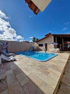 ein Swimmingpool vor einem Haus in der Unterkunft Casa de Veraneio com 4 quartos in Barra de São Miguel