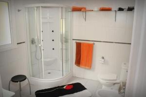 a white bathroom with a shower and a toilet at Casa Romeo Mit Kaminofen Und Sonnenterrasse in Guía de Isora