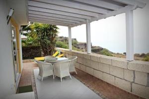 a patio with a table and chairs on a wall at Casa Romeo Mit Kaminofen Und Sonnenterrasse in Guía de Isora +28 photos