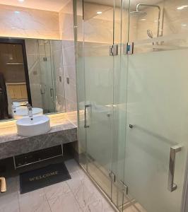 a bathroom with a glass shower and a sink at NAGA Frontier Apartment in Vientiane