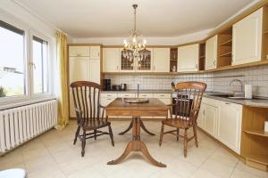 LietzowLandhaus Lietzow Ferienwohnung Beletage的配有木桌和椅子的厨房 更多17张照片