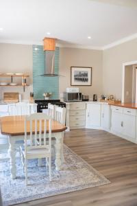 1 Annies Place Rawdons Country Estate في نوتنغهام رود: مطبخ مع طاولة خشبية وكراسي بيضاء