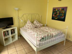 - une petite chambre avec un lit et une télévision dans l'établissement Großzügiges Studio In Einem Kleinen Fachwerkhaus, à Dömitz