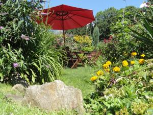 - une table avec un parasol dans un jardin fleuri dans l'établissement Ferienwohnung Anemoon In Millstatt, à Millstatt 27 autres photos