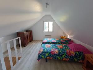 Un dormitorio con una cama y una escalera en un ático. en Gite 15 pers maxi proche Wimereux, en Belle-et-Houllefort