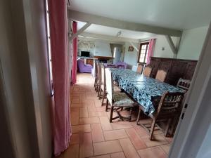 Un comedor con una mesa larga y sillas. en Gite 15 pers maxi proche Wimereux, en Belle-et-Houllefort