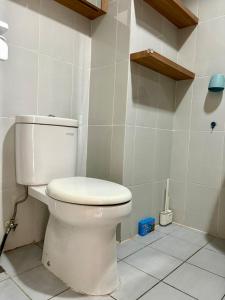 ein Badezimmer mit einer weißen Toilette in einem Zimmer in der Unterkunft Cozy Casa de Darco Studio Apt BSD W Pool & Gym in Kedeper