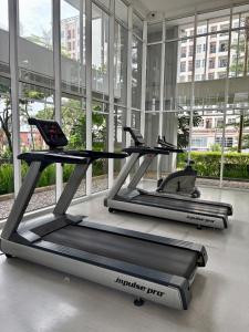 zwei Laufbänder in einem großen Gebäude mit Fenstern in der Unterkunft Cozy Casa de Darco Studio Apt BSD W Pool & Gym in Kedeper