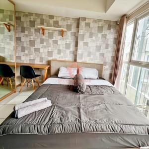 ein Schlafzimmer mit einem großen Bett in einem Zimmer in der Unterkunft Cozy Casa de Darco Studio Apt BSD W Pool & Gym in Kedeper