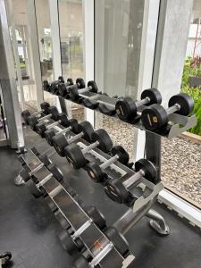 eine Reihe von Hanteln in einem Fitnessstudio in der Unterkunft Cozy Casa de Darco Studio Apt BSD W Pool & Gym in Kedeper + 2 Fotos