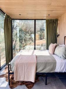 a bedroom with a bed and a large window at Perseus at The Retreat in Fredericksburg