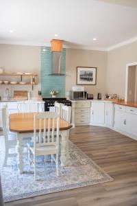 1 Annies Place Rawdons Country Estate في نوتنغهام رود: مطبخ مع طاولة خشبية وكراسي بيضاء