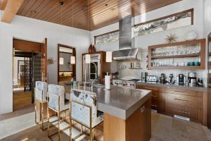 a kitchen with a island with chairs and a counter at Aspen Silverado in Aspen Valley Hospital Heliport +32 photos