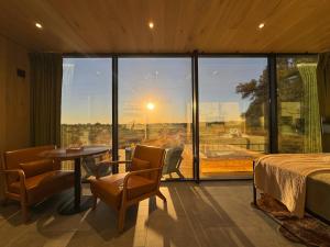 a room with a bed and a table and a large window at Perseus at The Retreat in Fredericksburg