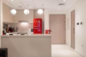 cocina con nevera roja en una habitación en The F1 Scene Designer Apartment With120 Inch, en Yas Island