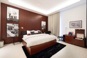 a bedroom with a large bed and a desk at The F1 Scene Designer Apartment With120 Inch in Yas Island