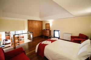 ポルト・モニスにあるCottage Ocean Viewのベッド1台と椅子2脚が備わるホテルルームです。