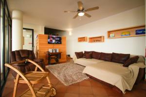 a living room with a couch and a ceiling fan at Cottage Ocean View in Porto Moniz