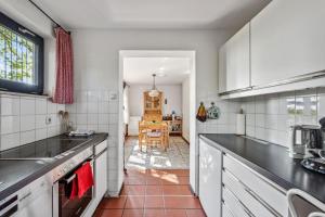 una cucina con mobili bianchi e ripiani neri di George Countryhouse a Lissendorf