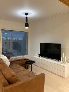 een woonkamer met een bank en een flatscreen-tv bij Villa Blacksmith in Rovaniemi