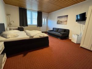 a hotel room with a bed and a couch at Hotel-Restaurant Christine in Lübz