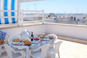 a table with a plate of food on a roof at Marealto Panorama in Porto Cesareo