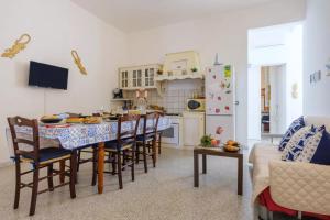 a kitchen and dining room with a table and chairs at Marealto Panorama in Porto Cesareo