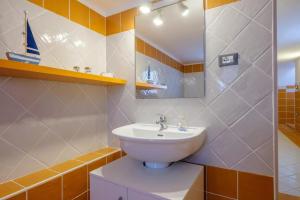 a bathroom with a sink and a sailboat on the wall at Marealto Panorama in Porto Cesareo +22 photos