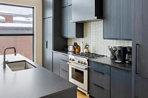 杰克逊Jackson Hole - Arts District West #302的厨房配有蓝色橱柜和炉灶烤箱。 更多32张照片