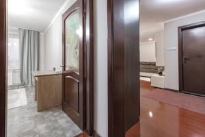 a room with a hallway with a door and a living room at Просторная квартира рядом с набережной in Pavlodar +20 photos