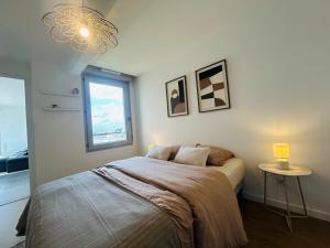 a bedroom with a bed and a window and a chandelier at Casa Orgemont in Les Ponts-de-Cé +8 photos