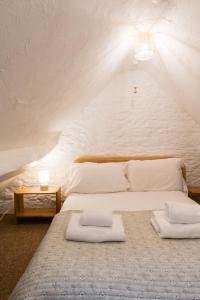 - une chambre avec un grand lit et un mur blanc dans l'établissement The Bullpen Cotswolds Farm Stay With Pool, à Lechlade