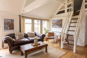 - un salon avec un canapé et une mezzanine dans l'établissement The Bullpen Cotswolds Farm Stay With Pool, à Lechlade