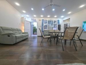 ein Wohnzimmer mit Tisch und Stühlen und einer Couch in der Unterkunft Chalet - House -Sand Adventures Oasis - Bidiyah - Oman in Jāḩis