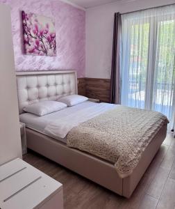 - une chambre avec un grand lit et un mur rose dans l'établissement Bocche di Cattaro Apartments, à Kotor