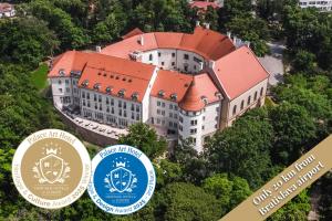 a large white building with an orange roof at Palace Art Hotel Pezinok in Pezinok