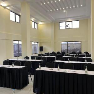 Una gran sala con mesas, sillas y ventanas. en The Avid Hotel, en Voi