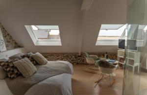 a bedroom with a bed and two skylights at Aux 13 Arches-Logis Hôtel Restaurant in Portbail