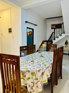 a dining room table with a flowered table cloth on it at Villa Happy Nest in Unawatuna