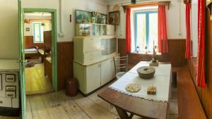 a kitchen with a table and a stove and a window at Gozdna koča Studeno in Kočevje
